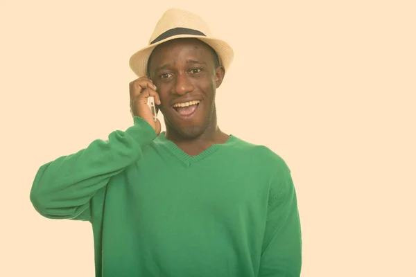 Młody, szczęśliwy Afrykanin uśmiecha się i rozmawia przez telefon komórkowy — Zdjęcie stockowe