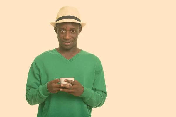 Νεαρός ευτυχισμένος Αφρικανός χαμογελάει και κρατάει την κούπα του καφέ — Φωτογραφία Αρχείου