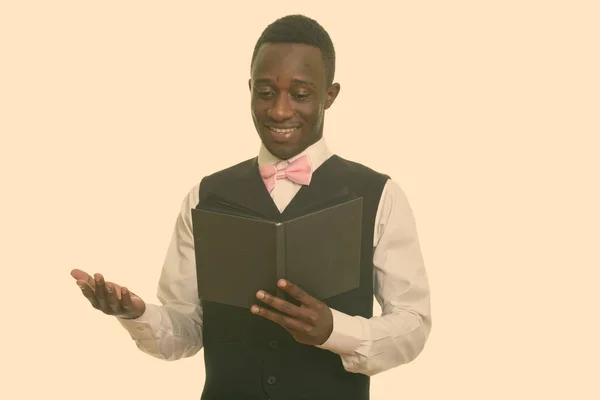 Jovem garçom africano feliz sorrindo e lendo livro — Fotografia de Stock