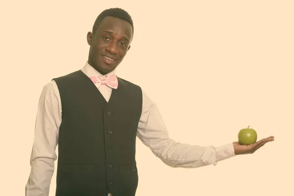 Joven camarero africano feliz sonriendo y sosteniendo manzana verde —  Fotos de Stock