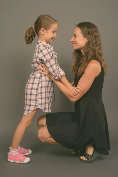 Mother and daughter bonding together against gray background — Stock Photo, Image