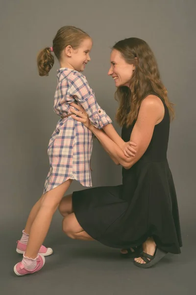 Mother and daughter bonding together against gray background — Stock Photo, Image