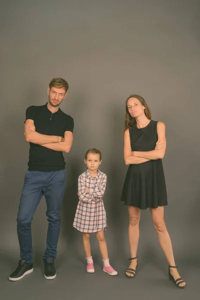 灰色の背景に対して一緒に若い幸せな家族の絆 — ストック写真