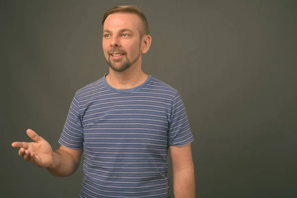 Blond bearded man with goatee against gray background