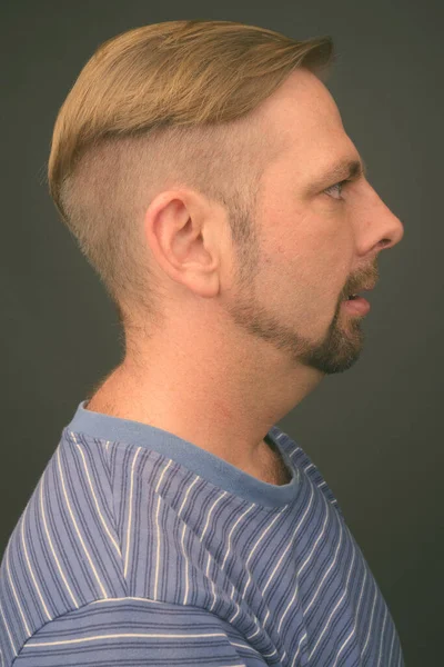 Blonder bärtiger Mann mit Spitzbart vor grauem Hintergrund — Stockfoto