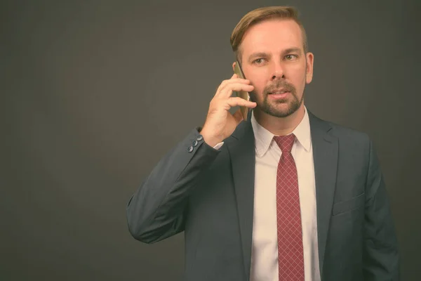 Hombre de negocios barbudo rubio con perilla sobre fondo gris —  Fotos de Stock