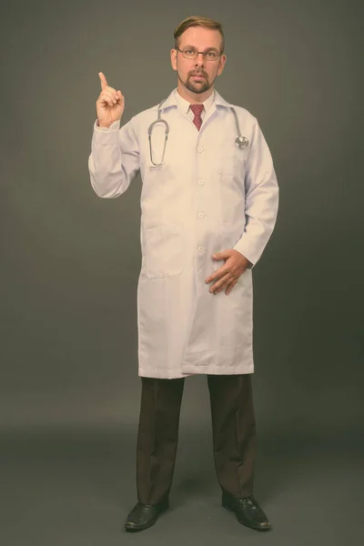 Blond bearded man doctor with goatee against gray background — Stock Photo, Image