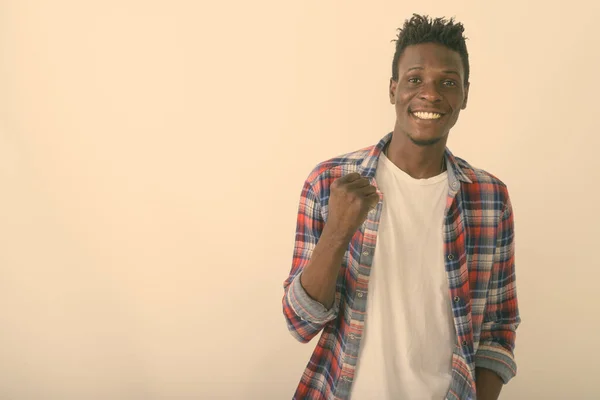 Estudio toma de joven feliz negro africano hombre sonriendo mientras mira motivado contra fondo blanco —  Fotos de Stock