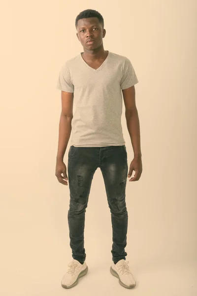 Full body shot of young black African man standing against white background — Stock Photo, Image