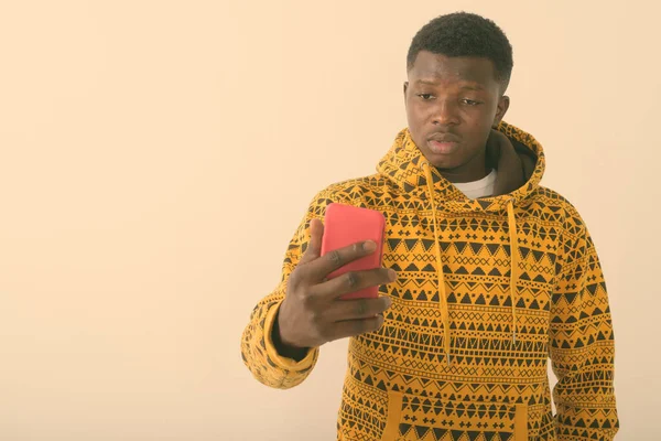 Студийный снимок молодого чернокожего африканца с помощью мобильного телефона на белом фоне — стоковое фото