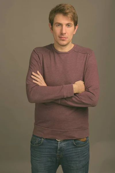 Retrato de hombre guapo contra fondo gris filmado en estudio — Foto de Stock