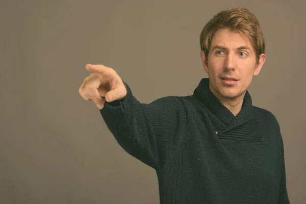 Porträt eines gutaussehenden Mannes vor grauem Hintergrund, aufgenommen im Studio — Stockfoto