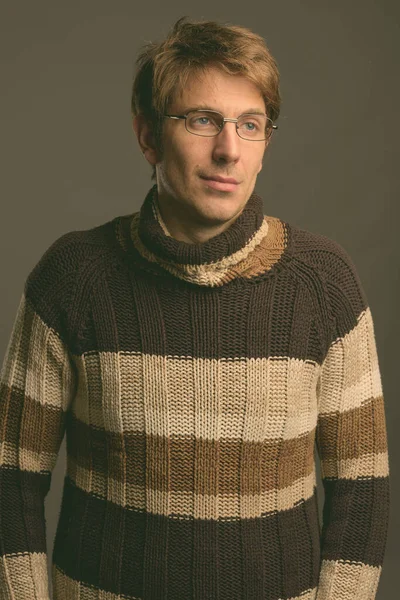 Retrato de hombre guapo contra fondo gris filmado en estudio —  Fotos de Stock