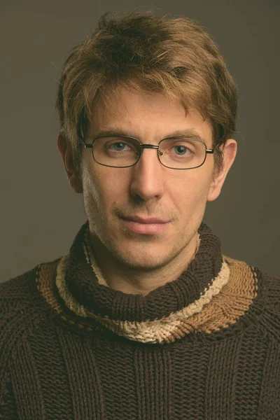 Retrato de hombre guapo contra fondo gris filmado en estudio —  Fotos de Stock