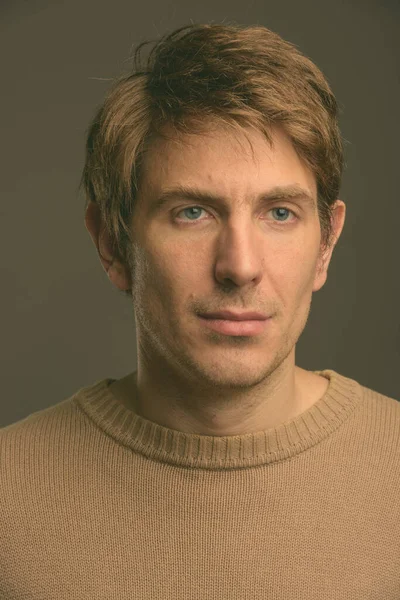 Retrato de hombre guapo contra fondo gris filmado en estudio —  Fotos de Stock
