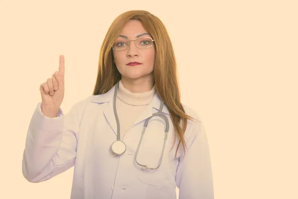 Studio shot of woman doctor pointing finger up — Stock Photo, Image