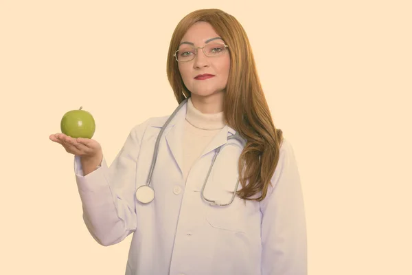 Studio shot of woman doctor holding green apple — Stock Photo, Image