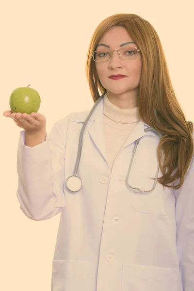 Студийный снимок женщины-врача с зеленым яблоком — стоковое фото