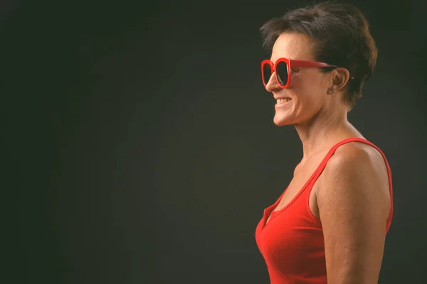 Maturo bella donna con i capelli corti contro sfondo nero — Foto Stock