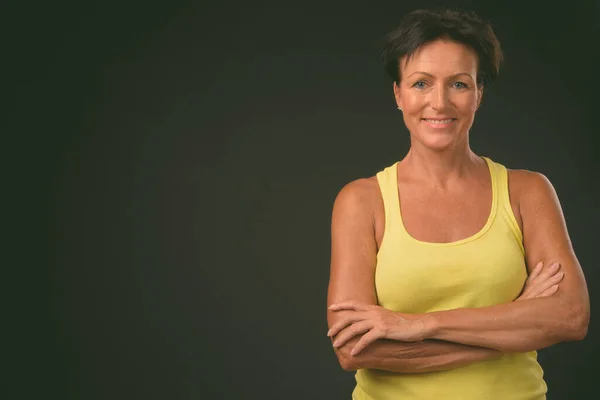 Mature beautiful woman with short hair against black background — Stock Photo, Image