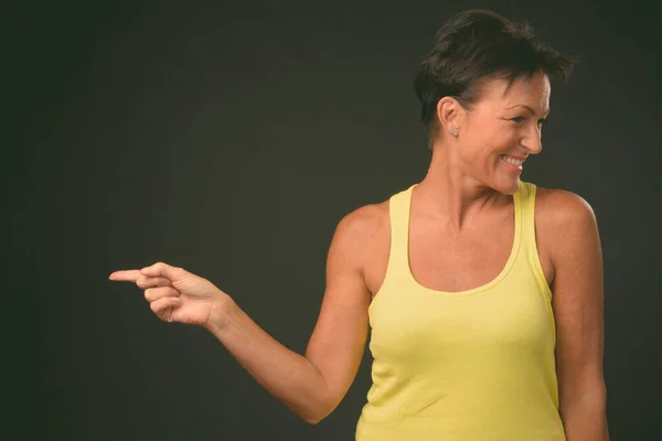 Mature beautiful woman with short hair against black background — Stock Photo, Image