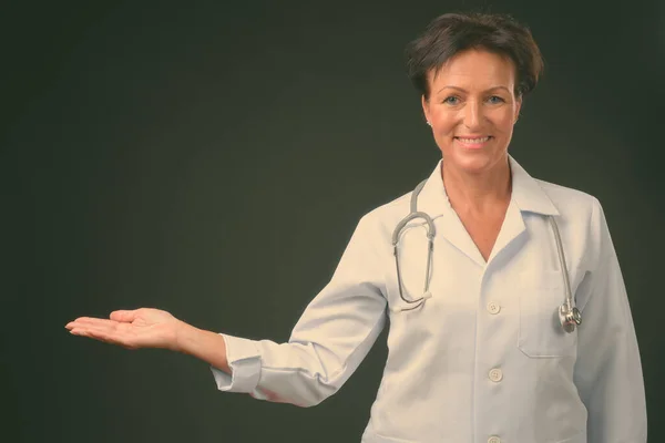 Зрелая красивая женщина врач с короткими волосами на черном фоне — стоковое фото