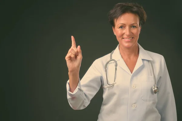 Maturo bella donna medico con i capelli corti contro sfondo nero — Foto Stock