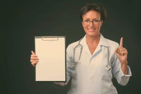 Madura hermosa mujer médico con pelo corto sobre fondo negro — Foto de Stock