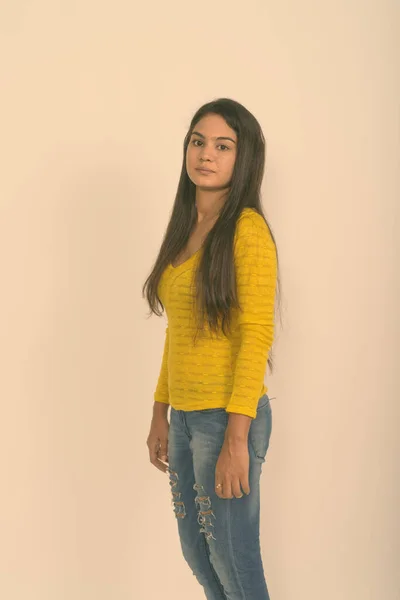 Studio shot of young Indian woman standing against white background — Stock Photo, Image