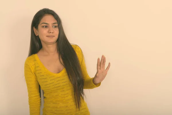 Estudio de la joven india mostrando señal de stop hand a un lado sobre fondo blanco — Foto de Stock