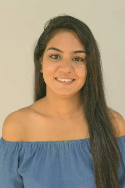 Rosto da jovem mulher indiana feliz sorrindo contra o fundo azul — Fotografia de Stock