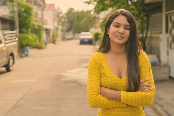 Joven mujer india feliz sonriendo con los brazos cruzados en las calles al aire libre —  Fotos de Stock