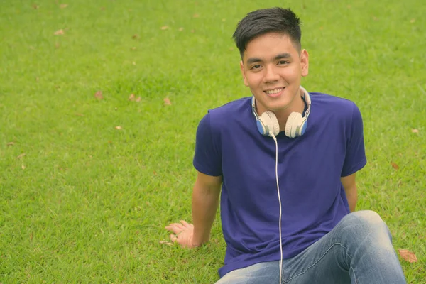 Giovane bello asiatico uomo relax a il parco — Foto Stock