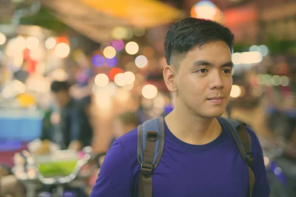 Young handsome Asian tourist man exploring at Chinatown in Bangkok, Thailand