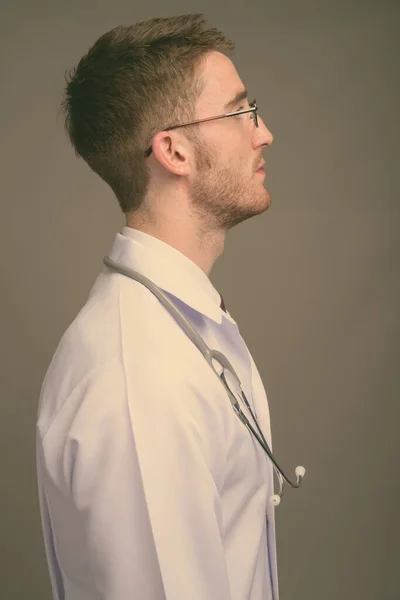 젊고 잘생긴 의사가 흰 배경에 안경을 쓰고 있는 모습 — 스톡 사진