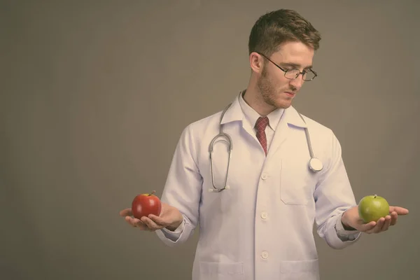 Jonge knappe man arts met bril tegen grijze achtergrond — Stockfoto