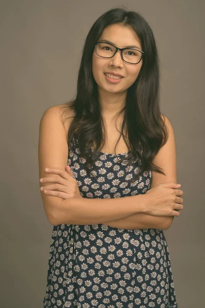 Asiatico donna indossare occhiali contro grigio sfondo — Foto Stock