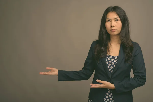 Asiatico donna indossare blu abito e cardigan maglione contro grigio sfondo — Foto Stock