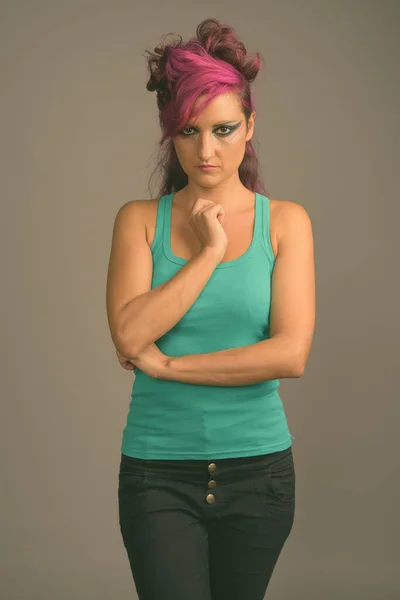 Красива жінка з рожевим волоссям і макіяжем на сірому фоні — стокове фото