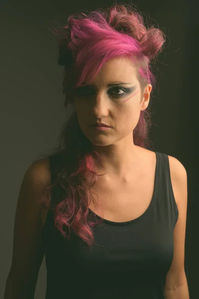 Mulher bonita com cabelo rosa e maquiagem contra fundo cinza — Fotografia de Stock