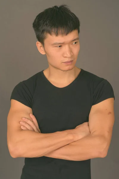 Studioaufnahme eines jungen Chinesen vor grauem Hintergrund — Stockfoto