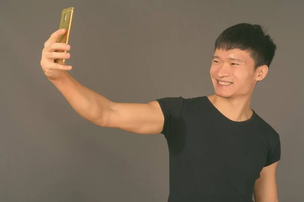 Знімок молодого китайця на сірому фоні — стокове фото