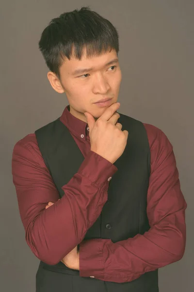 Молодий китайський бізнесмен проти сірого походження — стокове фото