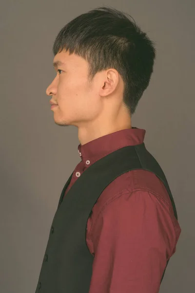 Gri arka plana karşı genç Çinli işadamı — Stok fotoğraf