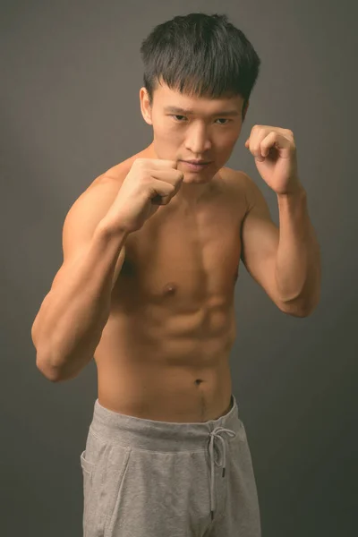 Młody Chińczyk bez koszuli na szarym tle — Zdjęcie stockowe