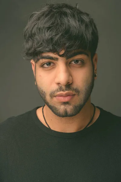 Joven hombre indio guapo contra fondo gris —  Fotos de Stock