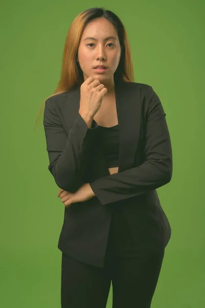 Ritratto di giovane imprenditrice asiatica sullo sfondo verde — Foto Stock