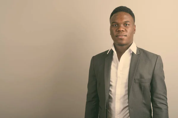 Joven hombre de negocios africano usando traje contra fondo blanco —  Fotos de Stock