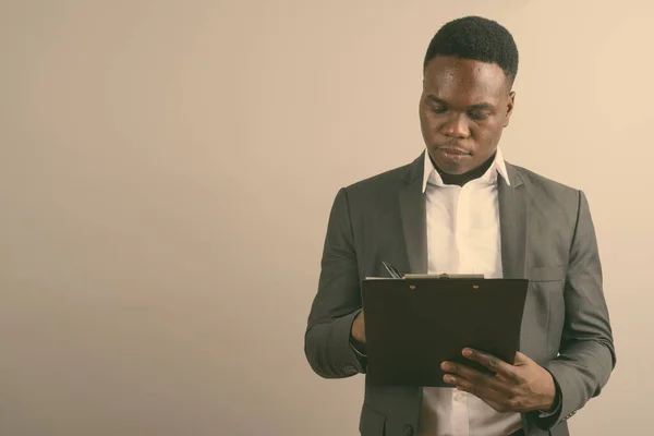 Jonge Afrikaanse zakenman draagt pak tegen witte achtergrond — Stockfoto