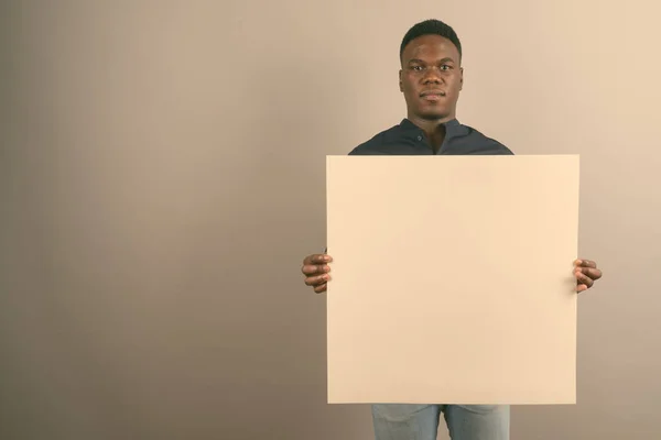 Jonge Afrikaanse zakenman met wit bord tegen witte achtergrond — Stockfoto